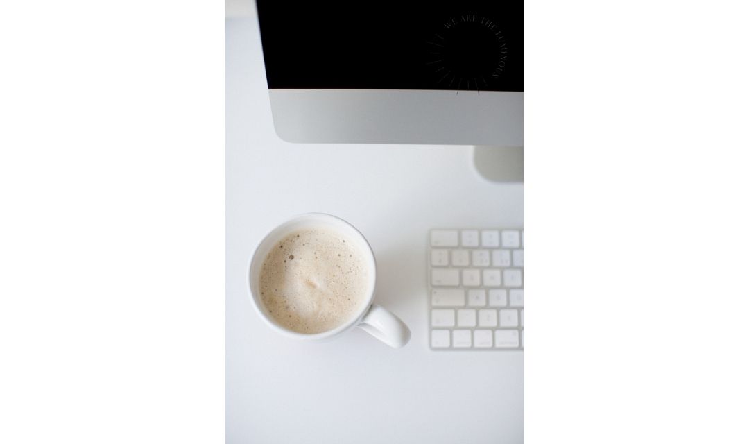 cup of coffee next to computer