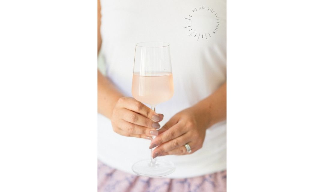 hands holding a glass of rosé