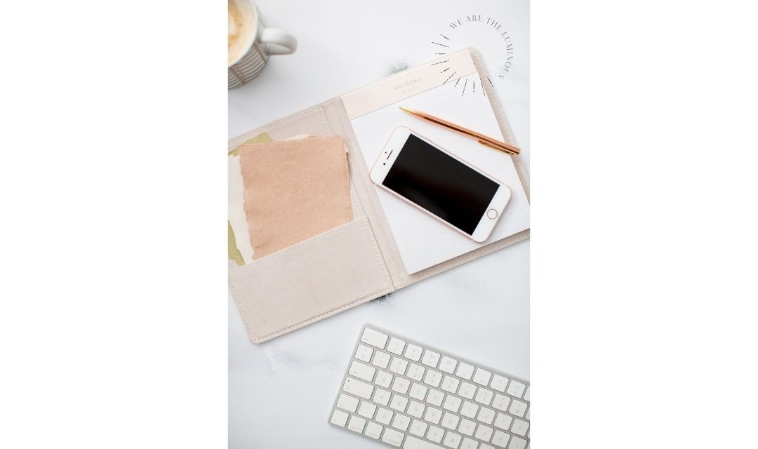 blush notebook with iphone and computer keyboard