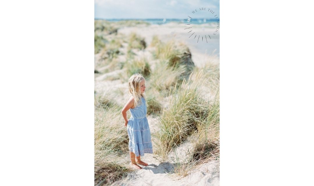 girl standing in sand dunes stock photo