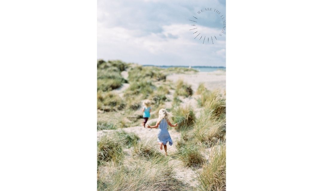 children running through sand dunes