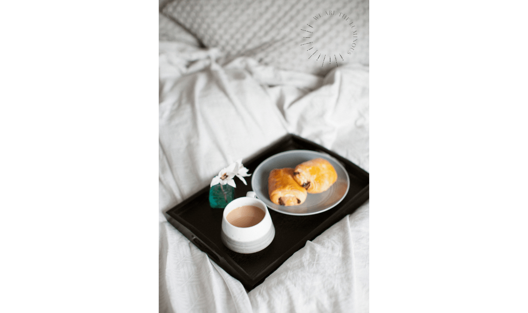 croissant and book in bed stock image
