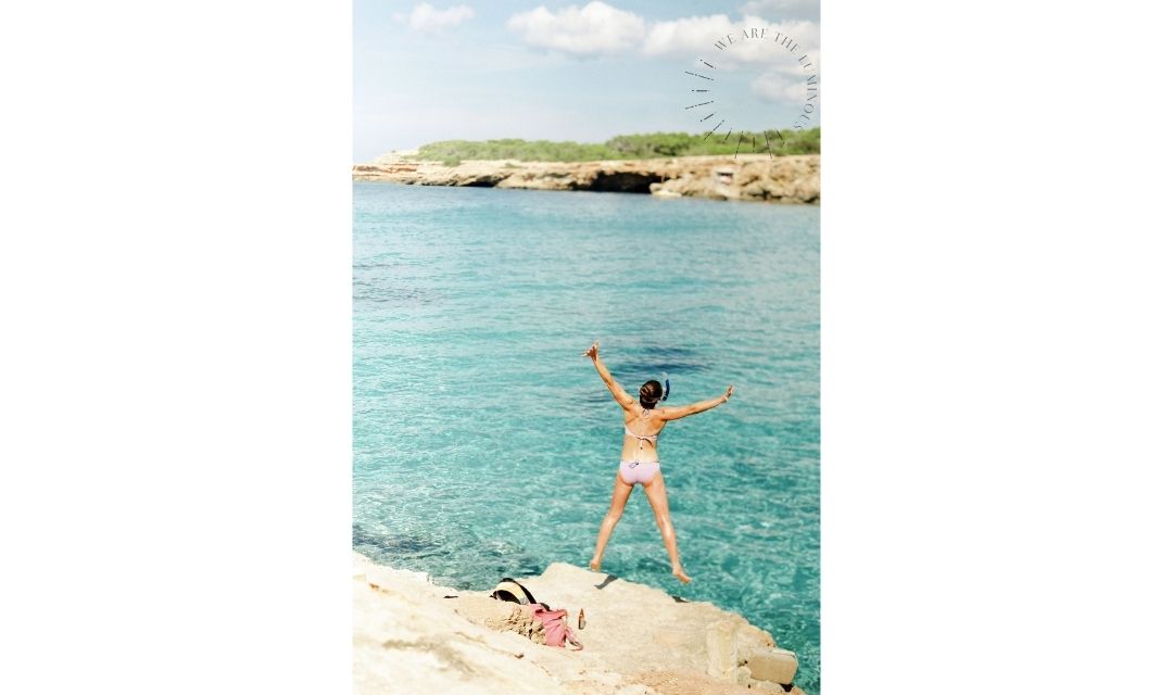 woman jumping into sea stock photo