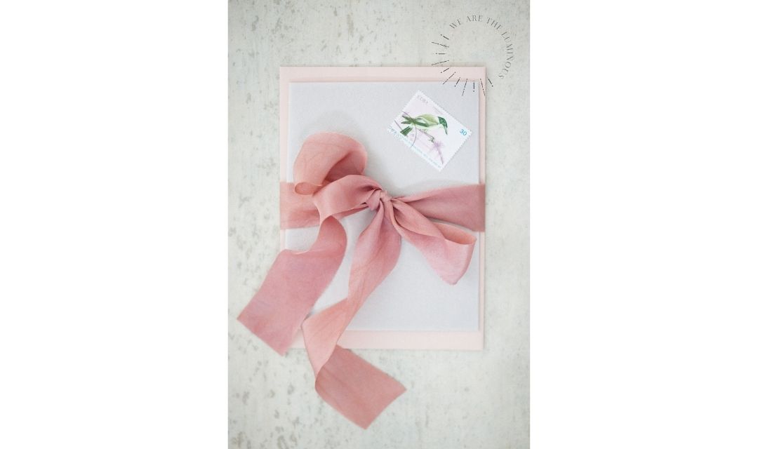 pink ribbon tied round envelope