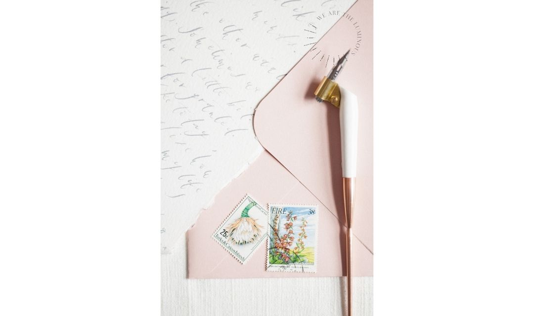 pink envelope with calligraphy pen