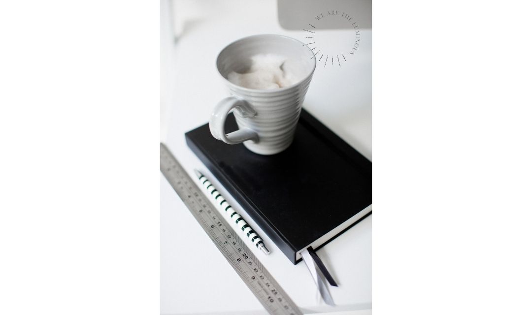 cup of coffee next to computer