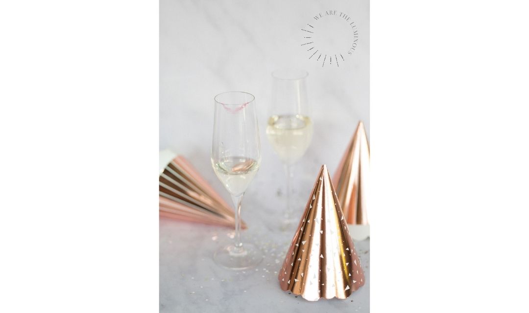 two champagne glasses with party hats