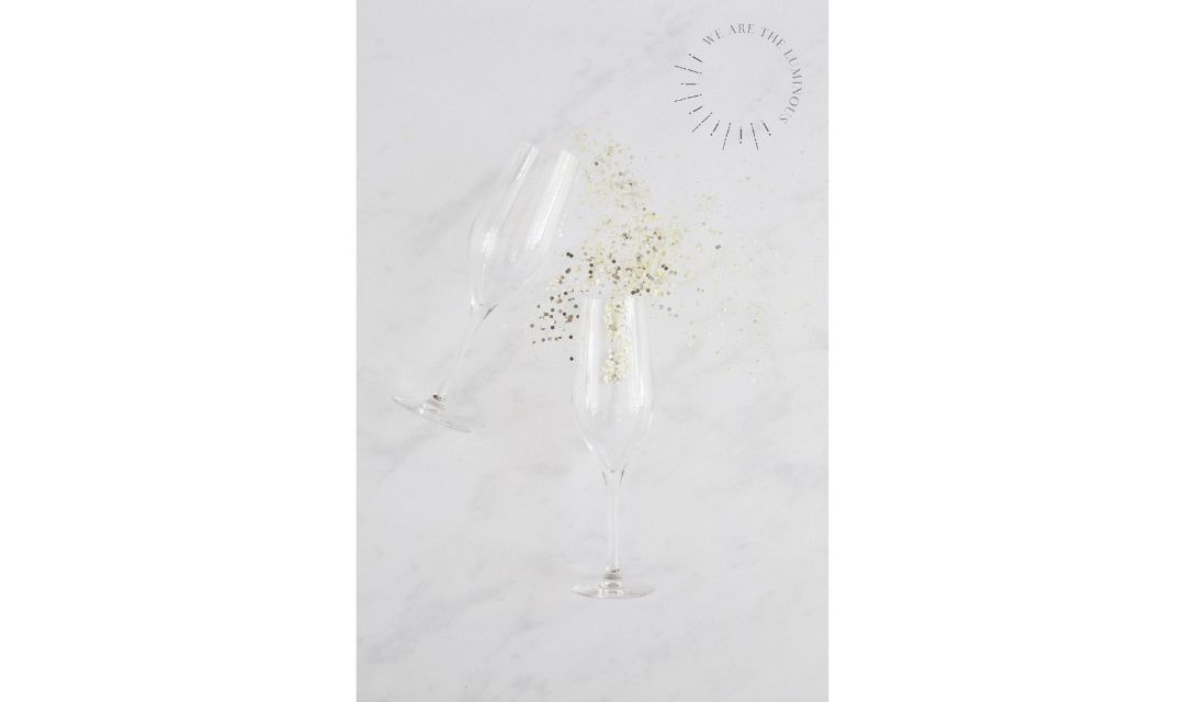 two champagne glasses and glitter champagne styled stock photography