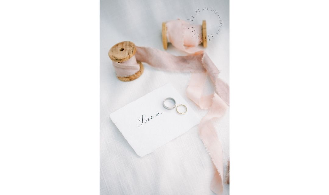 wedding rings with love quote and ribbons
